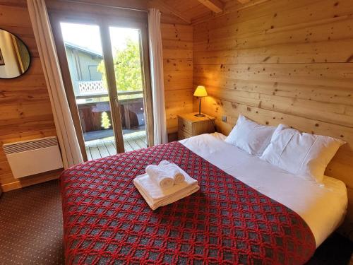 une chambre avec un lit avec deux serviettes dessus dans l'établissement Appartement duplex 3 pièces près des pistes, jardin, terrasse, Wi-Fi, parking couvert - FR-1-598-80, aux Gets