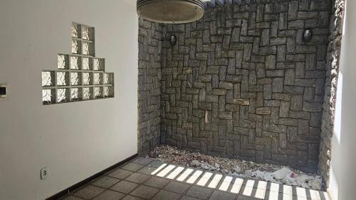 a bathroom with a brick wall and a window at Casa com suítes quartos praias e centro histórico in São Luís