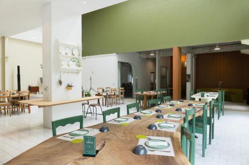 a dining room with wooden tables and green chairs at Bali hotel 