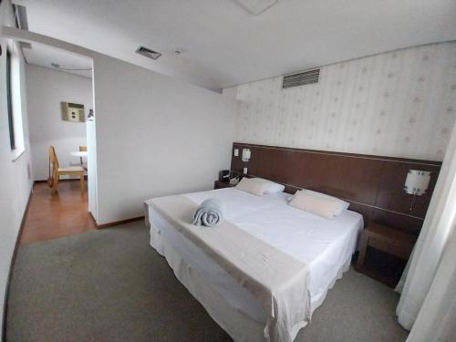una camera da letto con un grande letto bianco in una stanza di Osasco Trade & Convention Center a Osasco