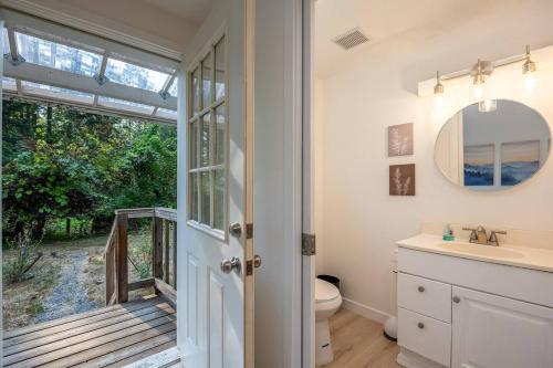 a bathroom with a toilet and a sink and a mirror at Updated Large River Front Home With Hot Tub in McKenzie Bridge