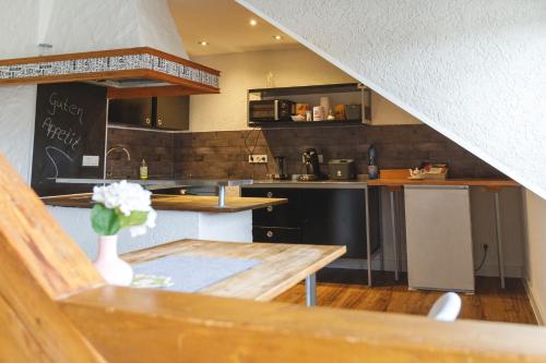 a kitchen with a table with a vase of flowers at 100 qm DG Wohnung 《Kehr wieder》Bexbach Saarland in Bexbach