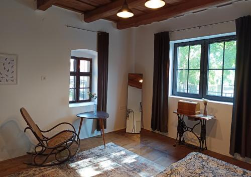 a living room with a chair and a table at HÁRS meg az alja in Balatonszárszó