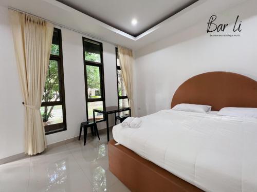 a bedroom with a large bed and some windows at Bali hotel 