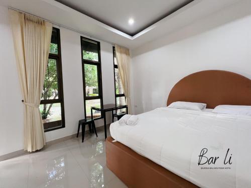 a bedroom with a large bed in a room with windows at Bali hotel 