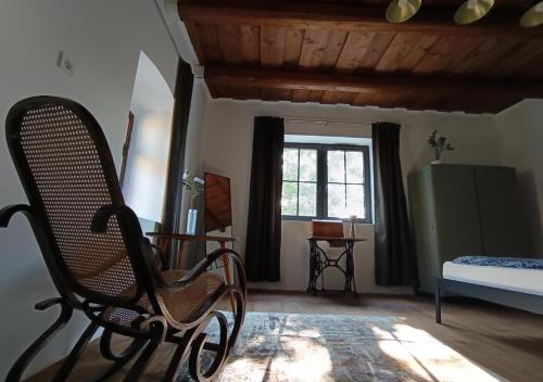 a chair in a room with a bed and a window at HÁRS meg az alja in Balatonszárszó