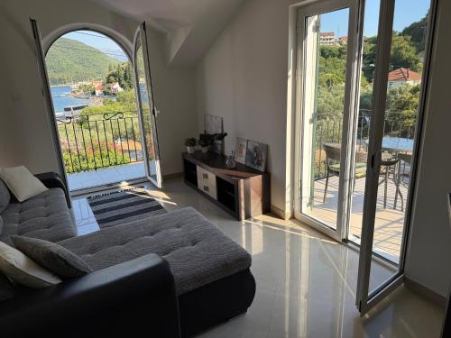 a living room with a couch and large windows at Villa Verde Oliva in Kamenari