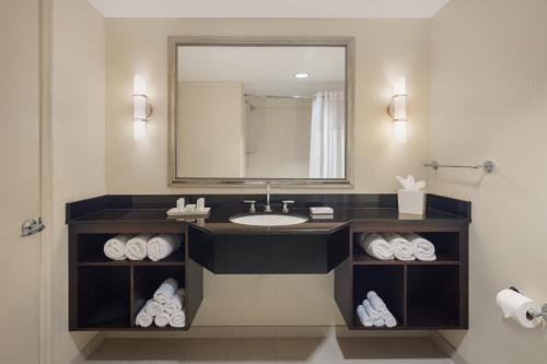 a bathroom with a sink and a mirror and towels at Plaza Suites On International Drive Near Universal Epic in Orlando