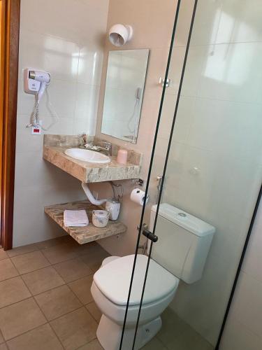 a bathroom with a toilet and a sink at Pousada Serra dos Sicalis in Serra Negra
