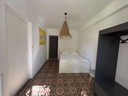 a bedroom with a white bed and a tile floor at Maison de caractère avec jardin arboré en Avignon in Avignon