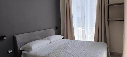 a bed in a bedroom with a large window at Misciù in Naples