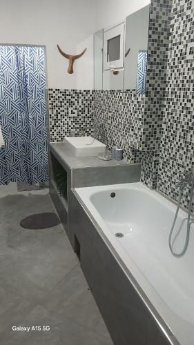 a bathroom with two sinks and a bath tub at Hotel LE BOEUF in Tuléar