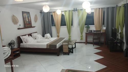 a bedroom with a bed and a table and chairs at Hotel LE BOEUF in Tuléar