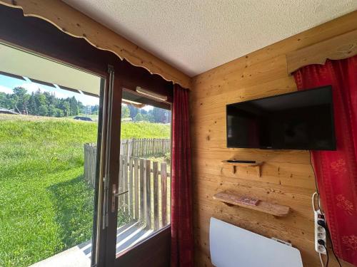 Cette chambre dispose d'une télévision murale et d'une fenêtre. dans l'établissement Appartement lumineux au pied des pistes, terrasse sud, 2 chambres - FR-1-642-84, à Morillon