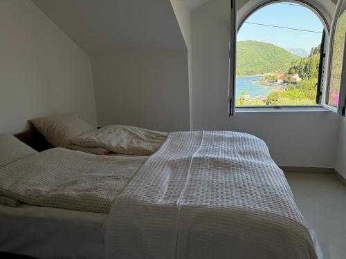 a bed in a room with a large window at Villa Verde Oliva in Kamenari