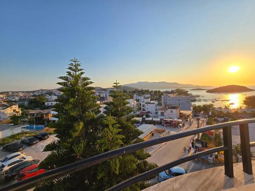 a view of a city at sunset from a balcony at Elio's Rooms in Ksamil