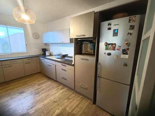 une cuisine avec un réfrigérateur blanc et une fenêtre dans l'établissement Maison vue mer, à Carqueiranne