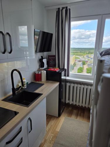 a small kitchen with a sink and a window at STUDIO dla 2 osób in Suwałki