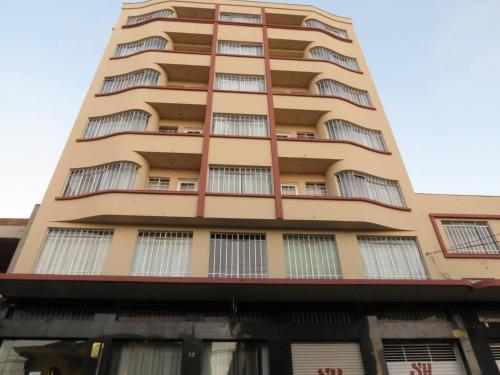 a tall apartment building with windows at Hotel Ponta Grossa São Marcos in Ponta Grossa