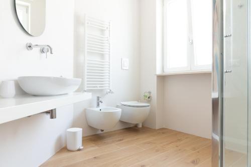 a white bathroom with a toilet and a sink at Altapuglia in Turi