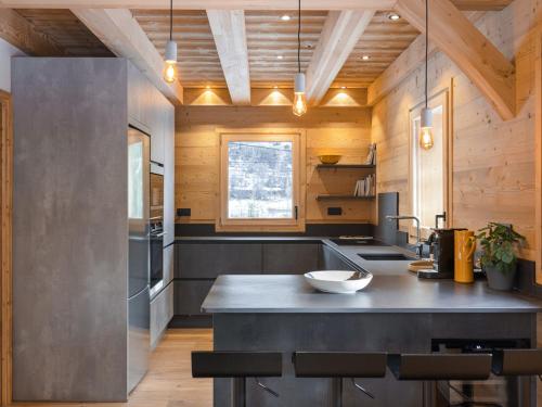 a kitchen with a large island in a kitchen with wooden walls at Chalet neuf 10 pers, charme et confort à Serre Chevalier - FR-1-808-20 in Le Monêtier-les-Bains
