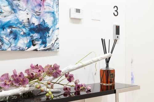 a vase with purple flowers on a counter next to a painting at Altapuglia in Turi