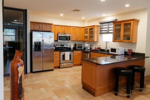 eine Küche mit Holzschränken und einem Edelstahlkühlschrank in der Unterkunft Ave Fénix Cozumel in Cozumel