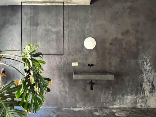 a concrete wall with a sink and a pendant light at Teddy Picker in Brussels