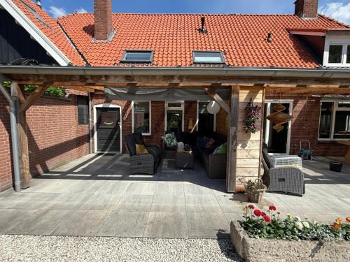 an outdoor patio with a roof on a house at Vakantiehuis Klaartje Kip Enschede tot 4 personen, landelijk gelegen! in Enschede