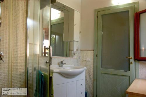 a bathroom with a sink and a mirror and a shower at "Il Piccolo Principe" - Residenze Gattopardu in Castiadas