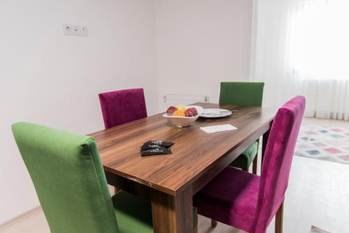 a dining room table with purple and green chairs at Oxseya Rezidans in Yomra