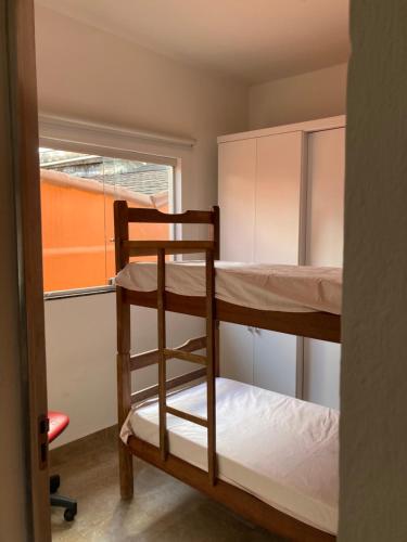 a room with two bunk beds and a window at Hostel Miscelânea in Sete Lagoas