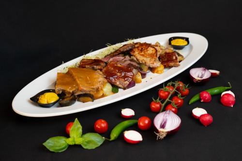 a plate of food on a table with vegetables at Hotel Marina in Fažana