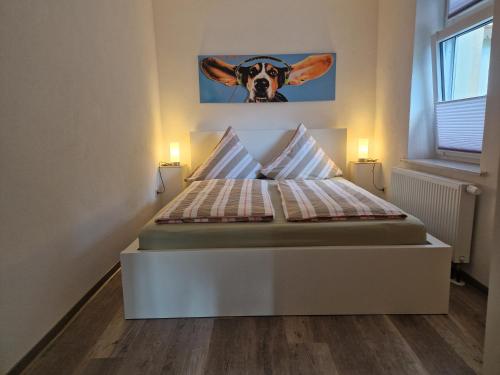 a bedroom with a bed with a cow picture on the wall at FeWo Herzenstölen in Sebnitz