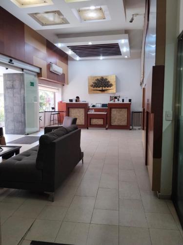 a waiting room with couches and tables in a building at Hotel Urban Express in Villahermosa