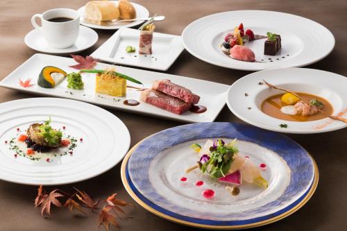 a table topped with plates of food and a cup of coffee at Hotel Neu Schloss Otaru in Otaru