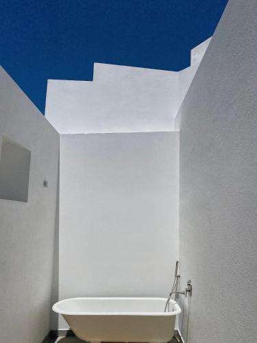 a bath tub in a bathroom with a blue ceiling at Casas do Largo- Amor é Cego in Estremoz