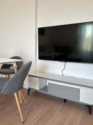 a living room with a large tv and a chair at Kuc-kuc Twin towers in Becici