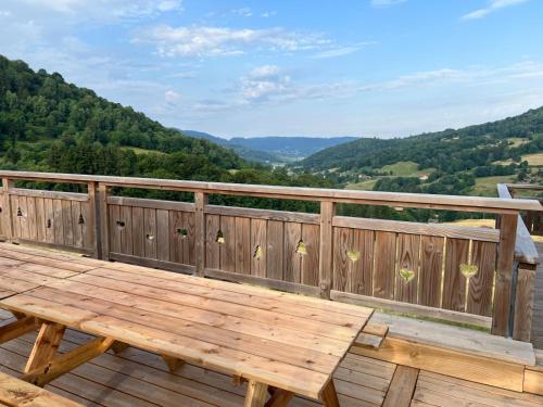 a wooden deck with a wooden picnic table on a balcony at BEL'M Amiral in Fresse-sur-Moselle