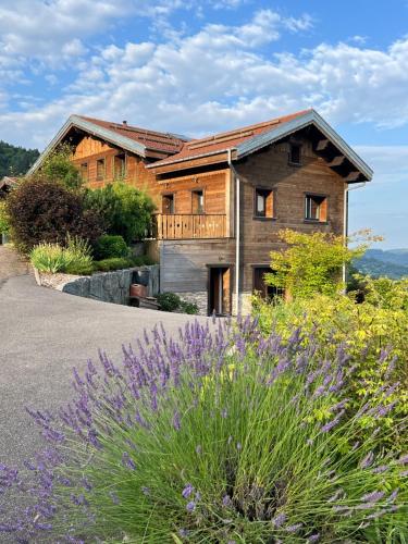 a wooden house with a yard with purple flowers at BEL'M Amiral in Fresse-sur-Moselle