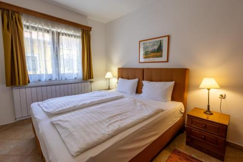 a bedroom with a large bed and a window at Friskó Panzió in Zalakaros