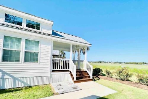 a white house with a porch and stairs at Vacation Cottage North Myrtle Beach #67 in Myrtle Beach