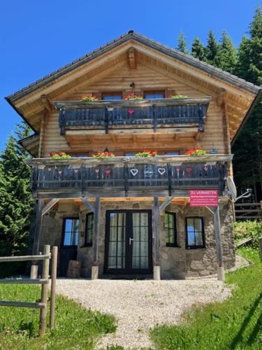 a log house with a balcony on top of it at CHALET GAMSBOCK Koralpe in Elsenbrunn