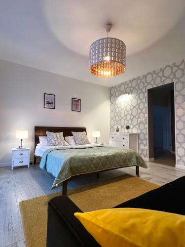a bedroom with a large bed and a chandelier at WiLLA APART in Władysławowo