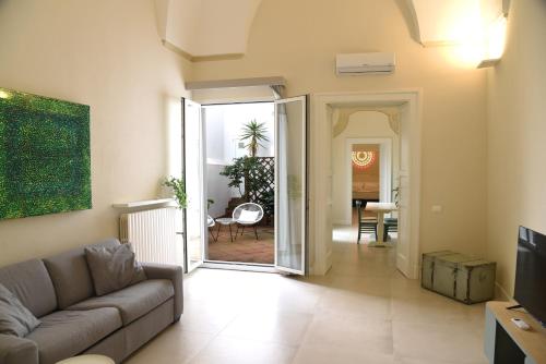 - un salon avec un canapé et une porte ouverte dans l'établissement Palazzo Rudiae - Sant'Irene, à Lecce