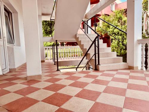 a hallway with a checkered floor and stairs at Mon in Bar