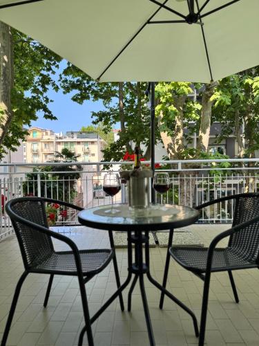 a table with two chairs and an umbrella at Blue Loft Hotel in Cesenatico
