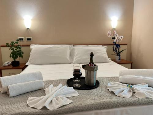 a bed with a bottle of wine and two towels at Blue Loft Hotel in Cesenatico