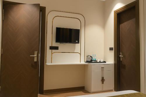 uma casa de banho com um espelho e uma televisão na parede em Hotel Parth Inn by IQ Hotels-Best Hotel Near Ram Mandir Ayodhya em Ayodhya