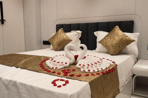 dois cisnes estão sentados em cima de uma cama em Hotel Parth Inn by IQ Hotels-Best Hotel Near Ram Mandir Ayodhya em Ayodhya
